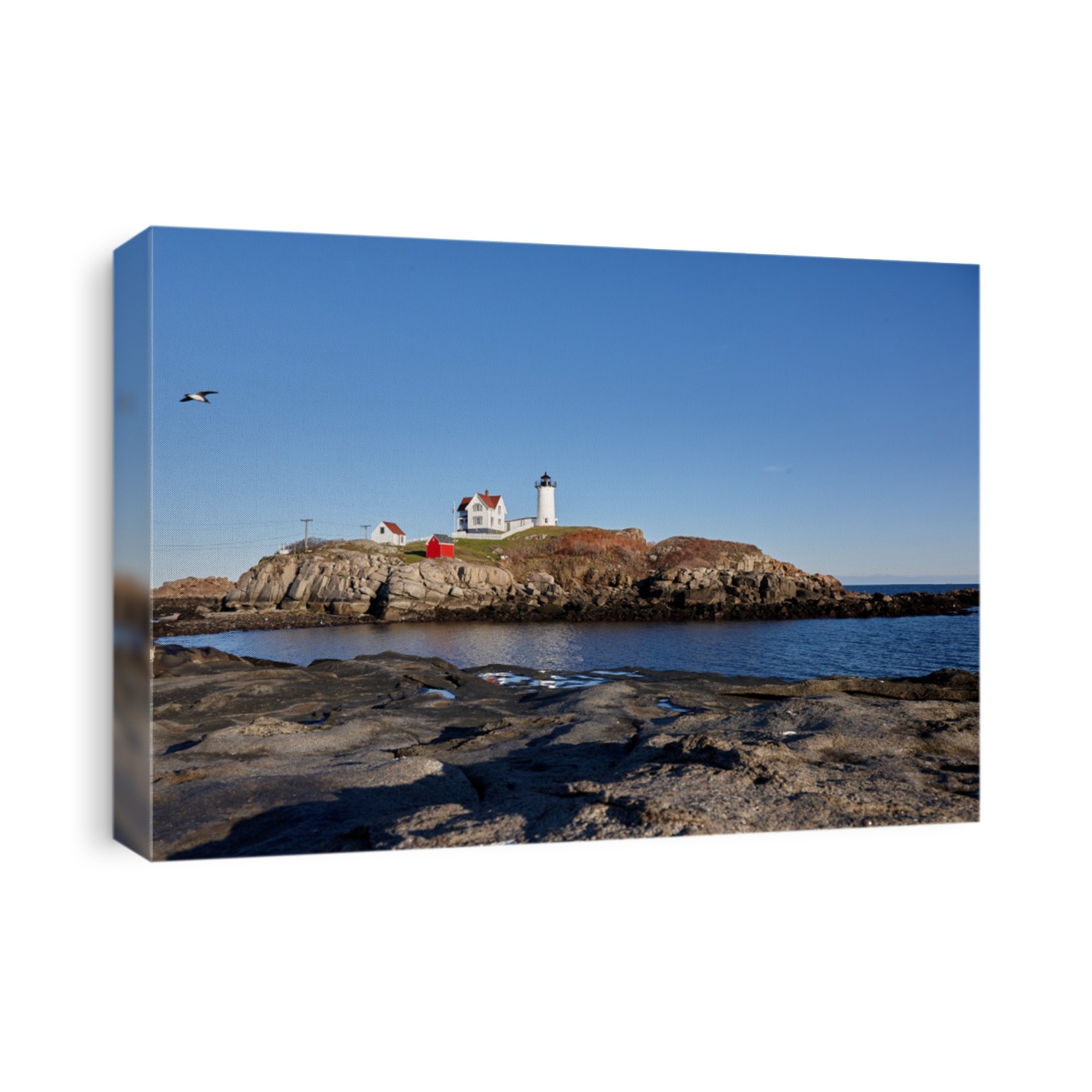 Cape Neddick Light Nubble lighthouse York Maine Blue skies rocks and ocean in the foreground